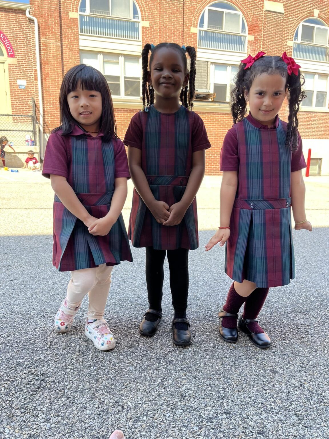 Three Resurrection Catholic School students in uniform outside the school